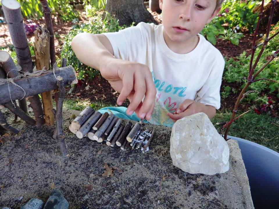 BOY BUILDING FIREWOOD PILE