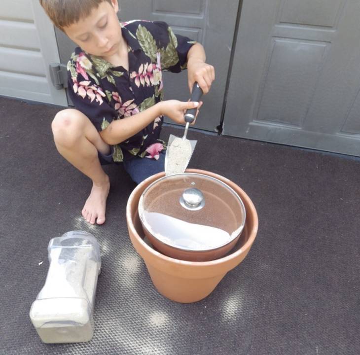 BOY FILLING POT WITH SAND