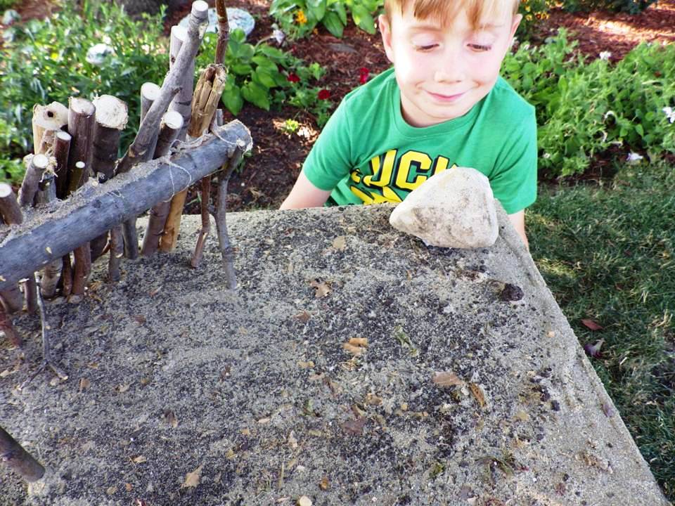 BOY PLACING ROCKS ON DIORAMA