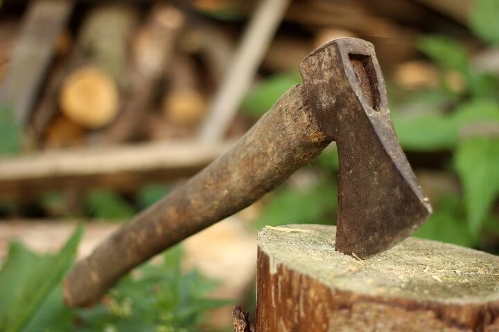 An Old Axe Sits On A Log