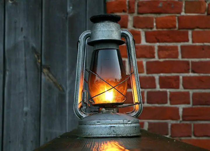 An Old Oil Lamp Sits On A Shelf