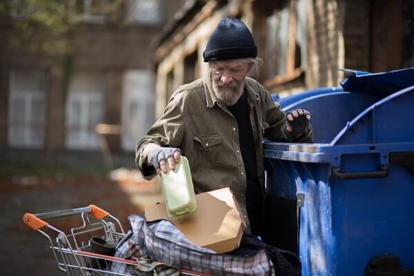 Homeless Man Digging Through The Trash