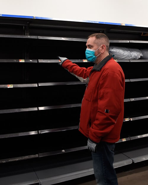 Man in Flu Mask Looking At Empty Shelves