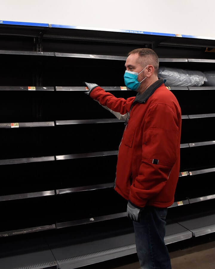 Man in Mask Looking at Empty Shelves