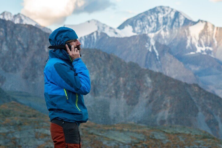 Man Using Satellite Phone in Wilderness