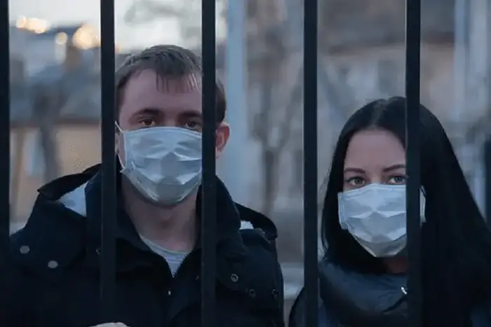 People Behind Bars With Facemasks